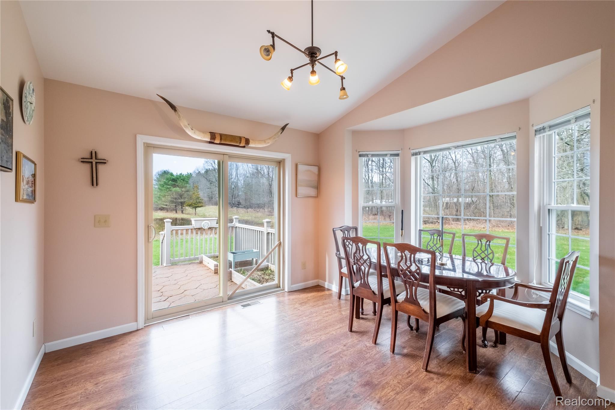 4210 Evans Road Holly, MI 48442 - Photo 12 of 23 Dining space with a chandelier, plenty of natural light, light wood finished floors, and vaulted ceiling
