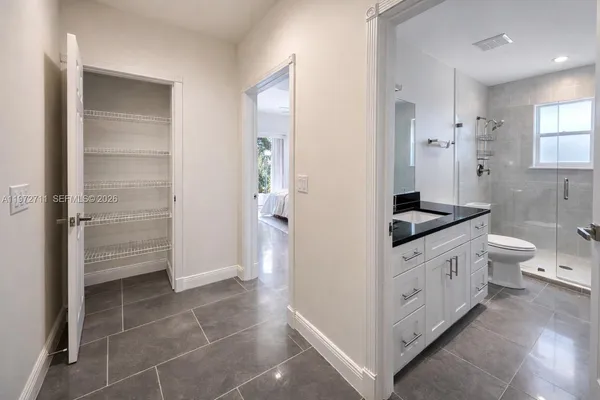 a bathroom with a granite countertop sink a toilet and shower