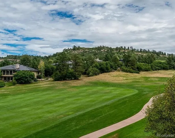 a view of a green field with wooden fence