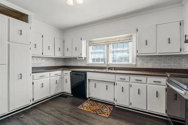 a kitchen with granite countertop cabinets stainless steel appliances and wooden floor