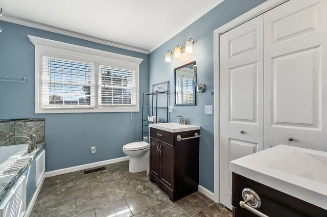 a bathroom with a tub sink and granite