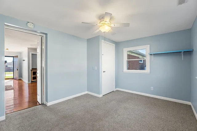 a view of a big room with wooden floor closet and fan
