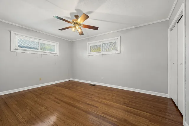 a view of empty room with wooden floor