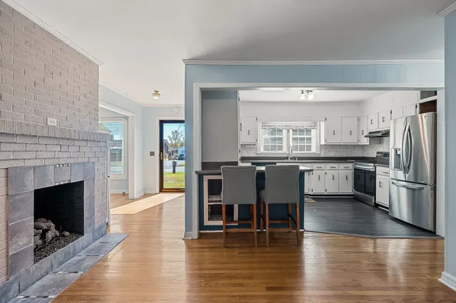 a living room with wooden floor and a fireplace