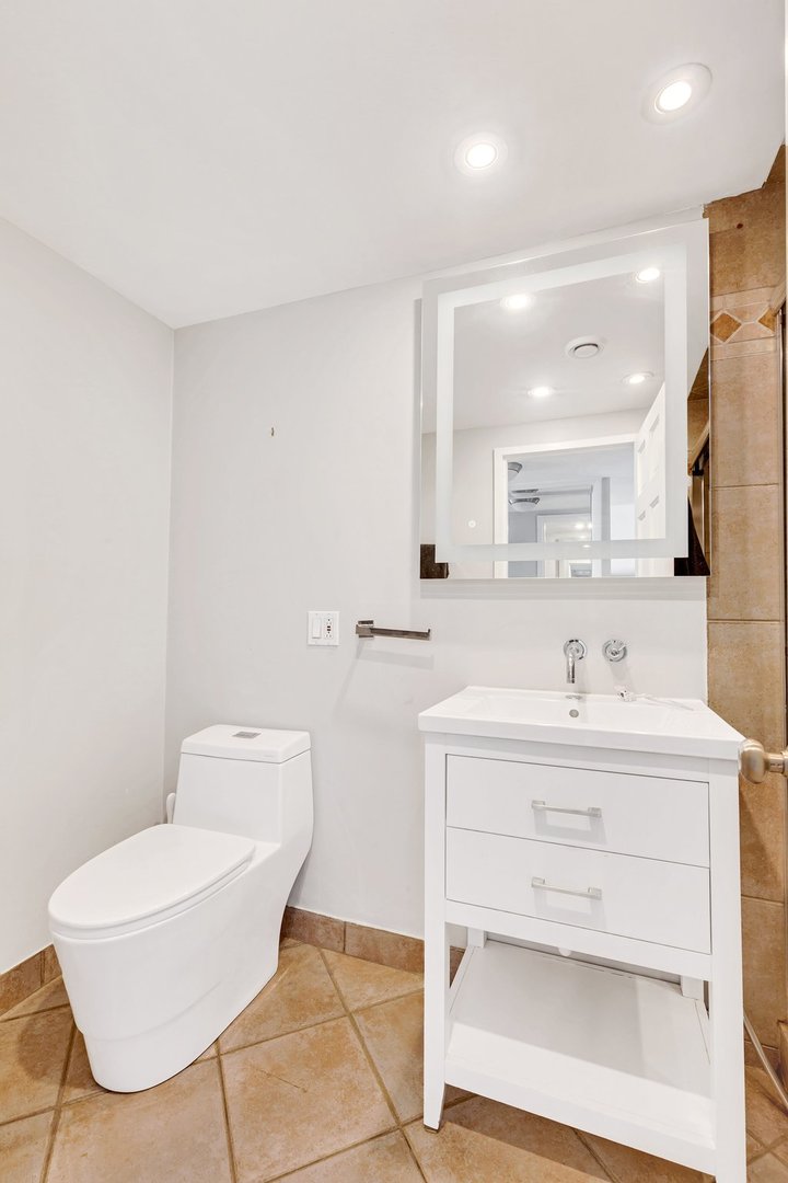 1 East Schiller Street, Unit 12A Chicago, IL 60610 - Photo 4 of 13 a bathroom with a sink a toilet and a mirror