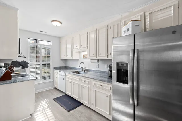 a kitchen with a refrigerator sink and cabinets