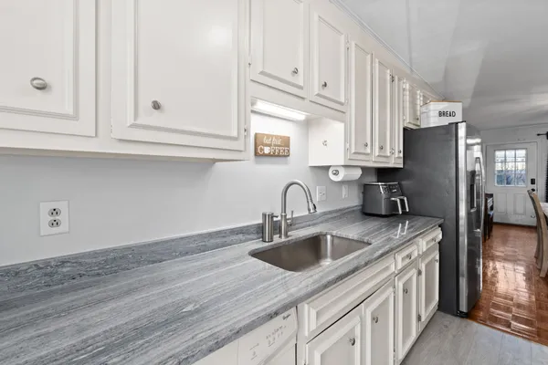 a kitchen with stainless steel appliances granite countertop white cabinets a sink and dishwasher