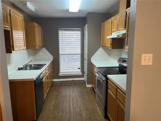 a kitchen with granite countertop a sink stove and refrigerator