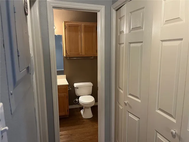 a bathroom with a granite countertop toilet and a sink