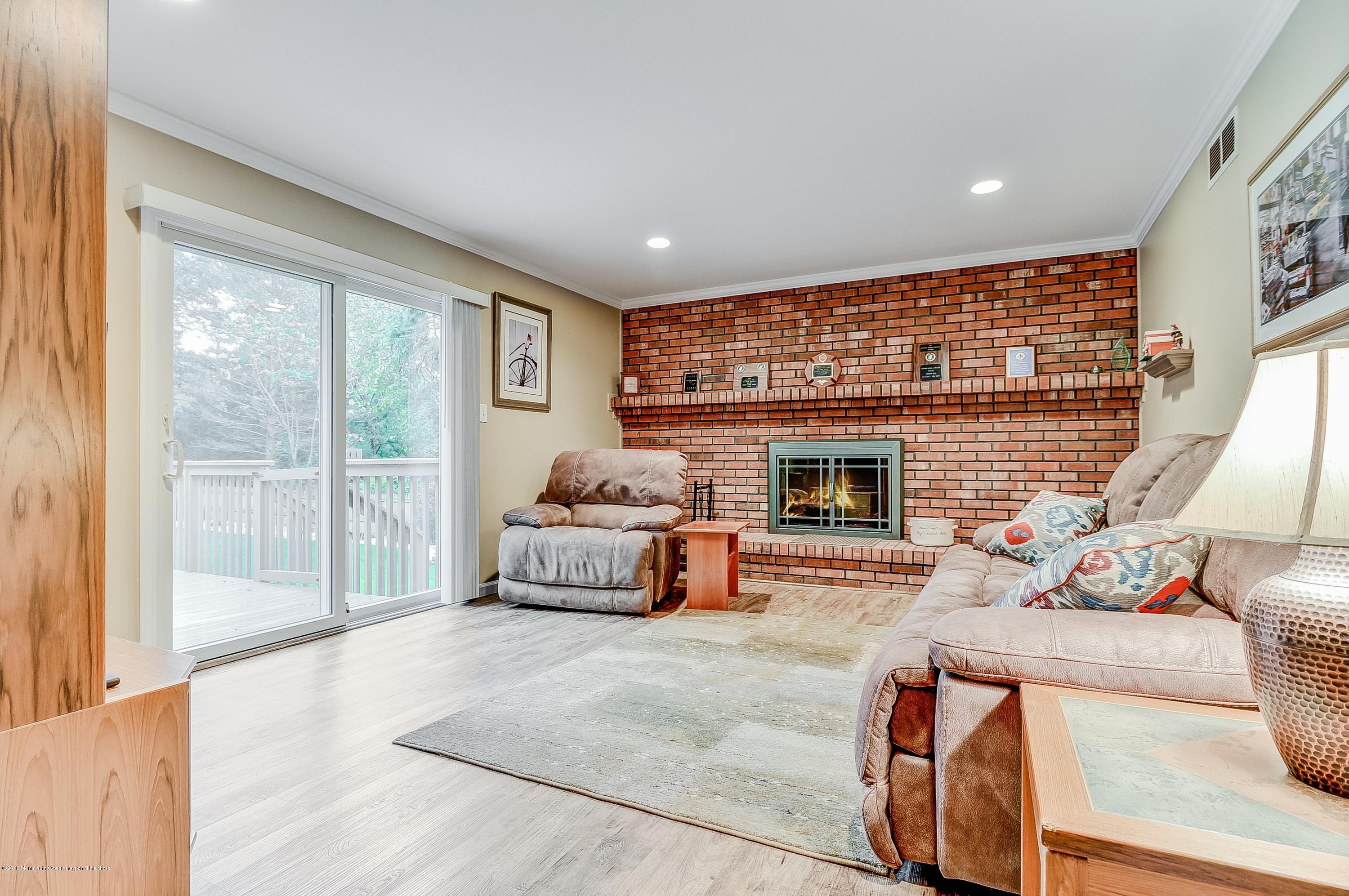 12 Addison Road Howell, NJ 07731 - Photo 13 of 25 a living room with furniture a fireplace and a flat screen tv