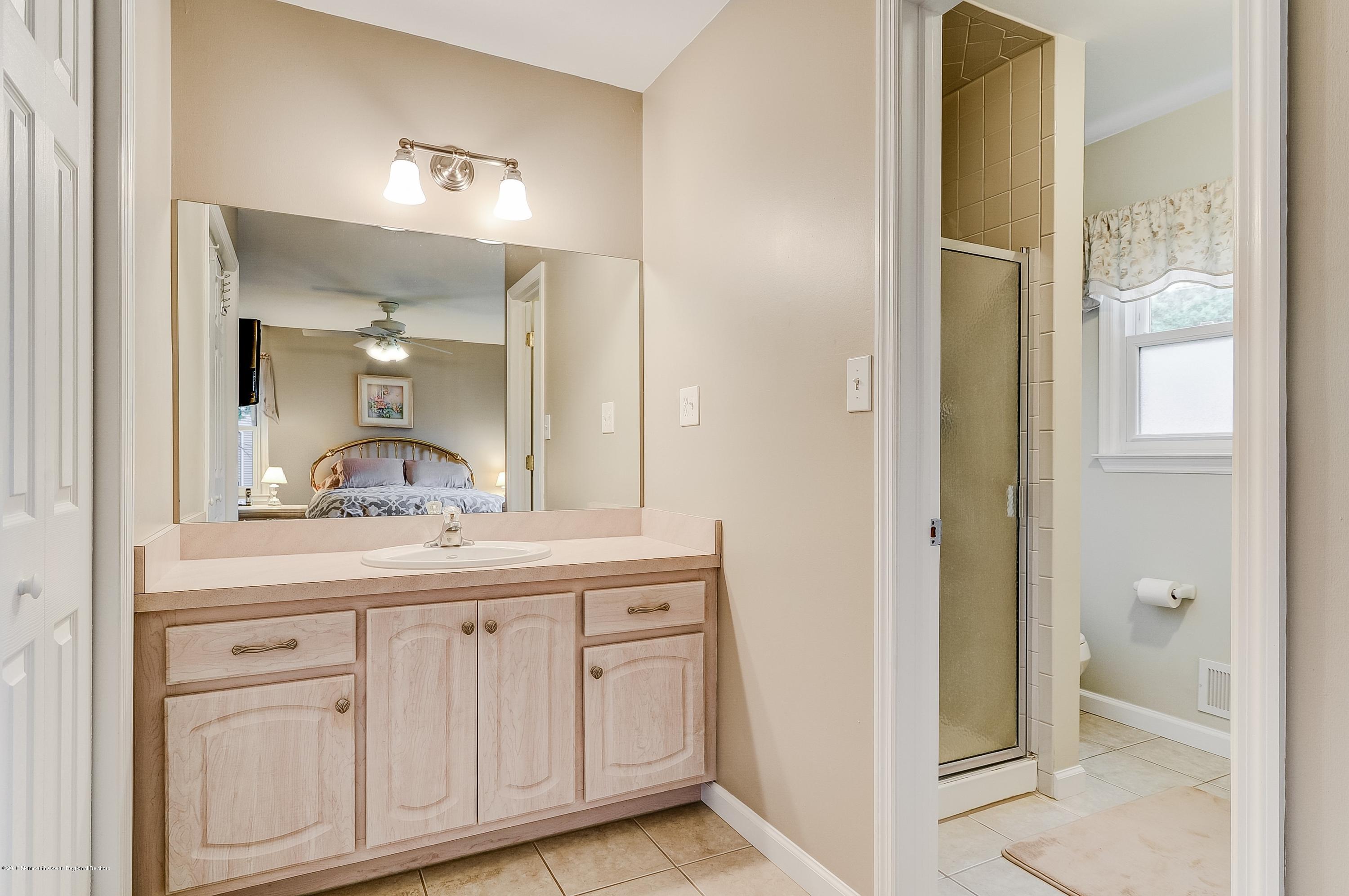 12 Addison Road Howell, NJ 07731 - Photo 18 of 25 a en suite bathroom with a granite countertop sink and a mirror
