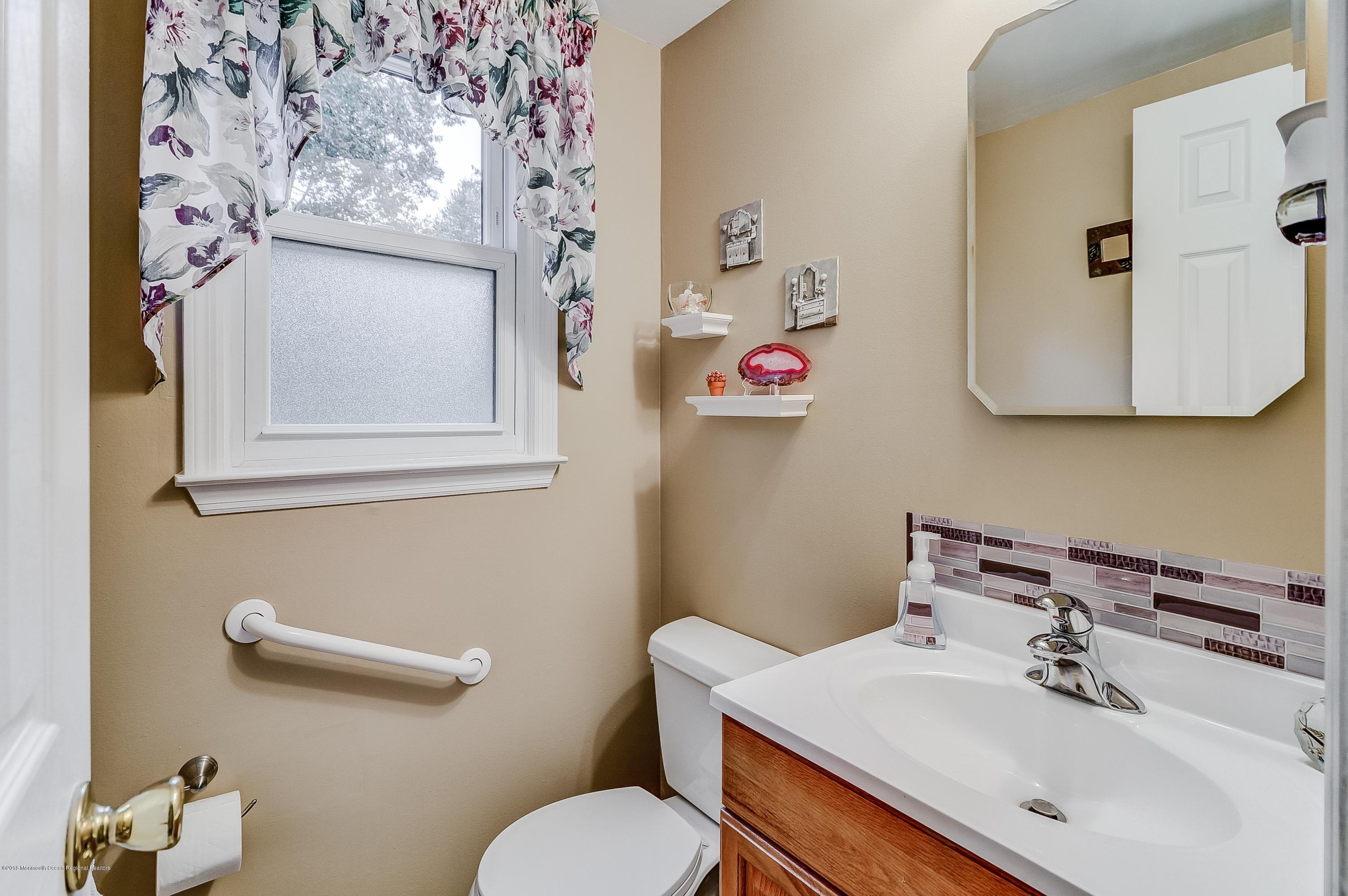 12 Addison Road Howell, NJ 07731 - Photo 23 of 25 a bathroom with a sink mirror and toilet