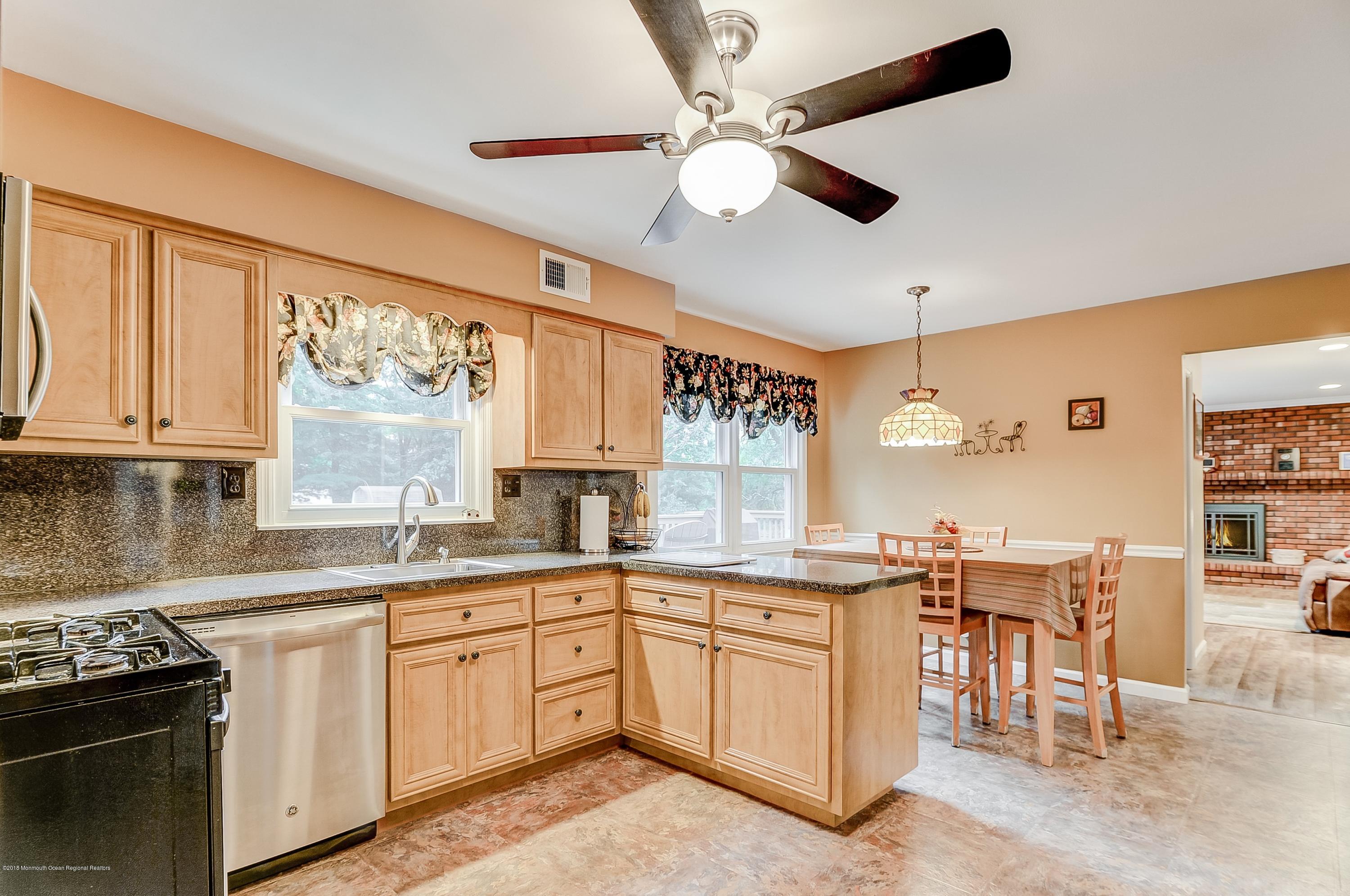 12 Addison Road Howell, NJ 07731 - Photo 5 of 25 a kitchen with a stove a sink a dining table and chairs