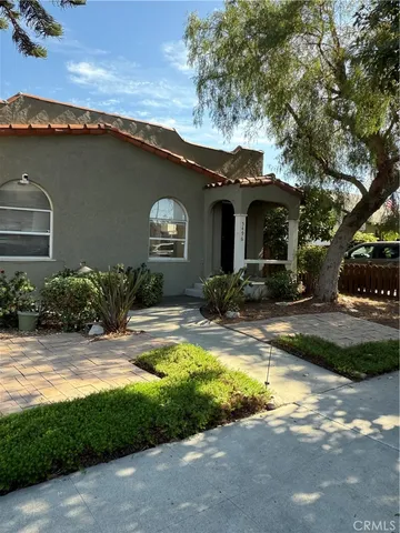 a view of a house with pool and chairs under an umbrella