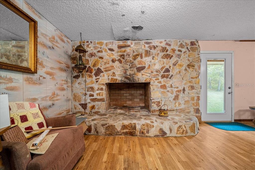 7173 West R Thomas Road Keystone Heights, FL 32656 - Photo 41 of 59 a living room with a fireplace and a flat screen tv