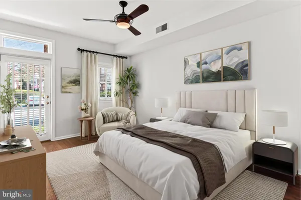 a view of a livingroom with wooden floor and a ceiling fan