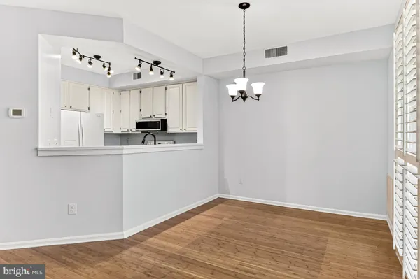a kitchen with stainless steel appliances white cabinets and a refrigerator