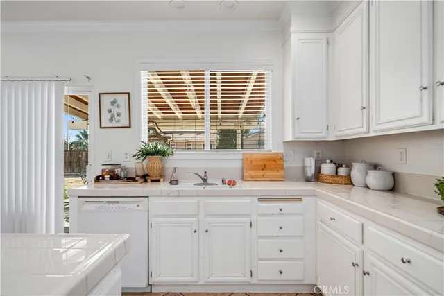 a kitchen with cabinets appliances a sink and a window