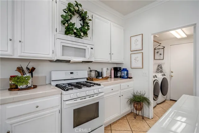 a kitchen with stainless steel appliances white cabinets a stove a sink and a refrigerator