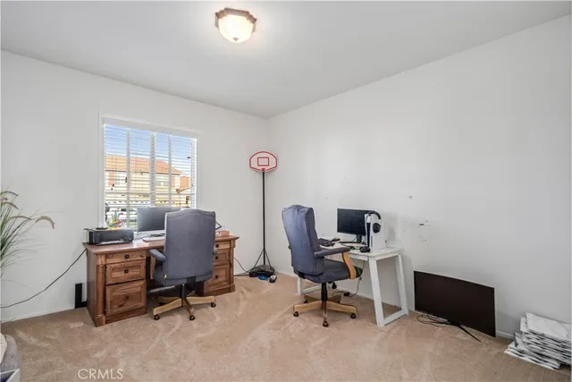 a view of a workspace with furniture and a window