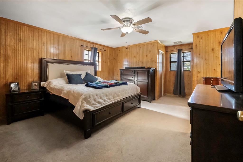 232 South Moseley Street De Leon, TX 76444 - Photo 12 of 39 a spacious bedroom with a bed and a chandelier