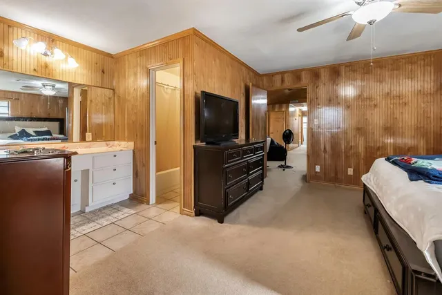 a spacious bedroom with a bed and a flat screen tv