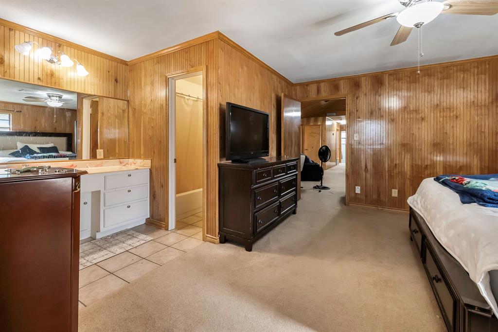 232 South Moseley Street De Leon, TX 76444 - Photo 14 of 39 a spacious bedroom with a bed and a flat screen tv