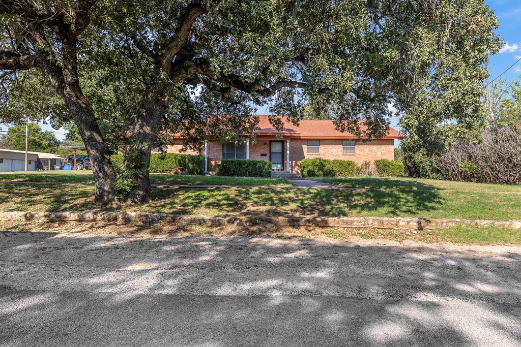 232 South Moseley Street De Leon, TX 76444 - Photo 29 of 39 a front view of a house with a yard and garage