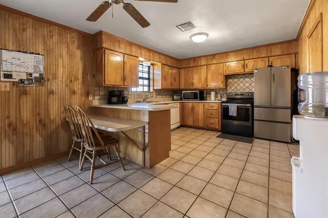 a kitchen with appliances cabinets and furniture