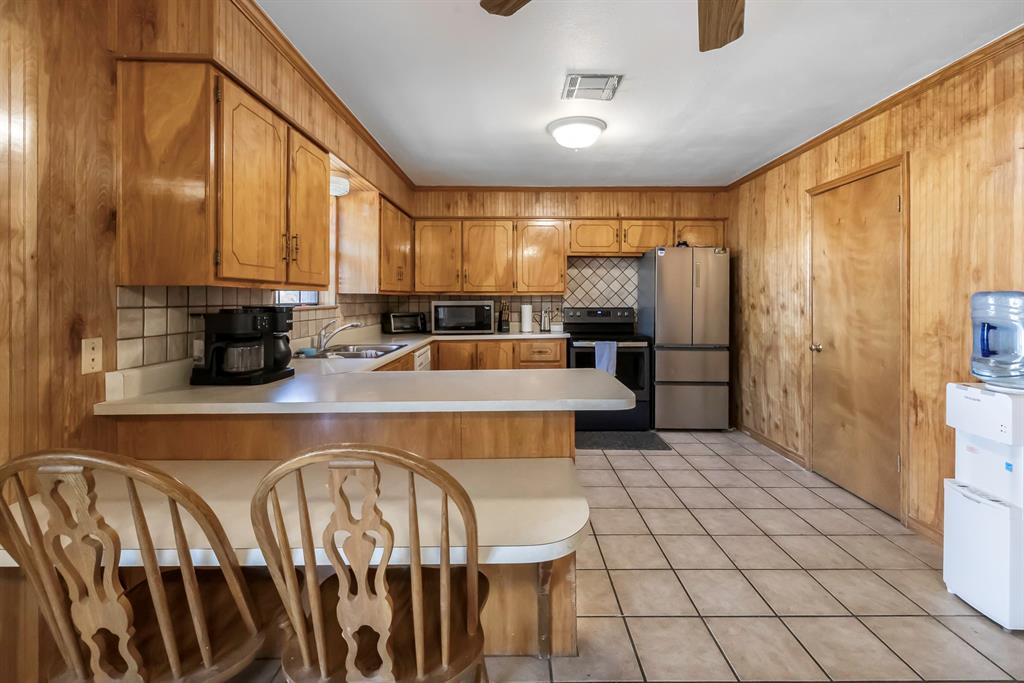 232 South Moseley Street De Leon, TX 76444 - Photo 7 of 39 a kitchen with stainless steel appliances a stove a sink and cabinets