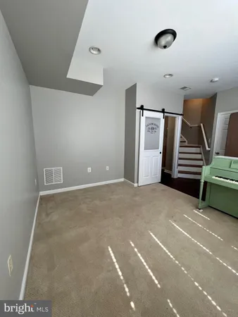 a view of an empty room with stairs and a ceiling fan