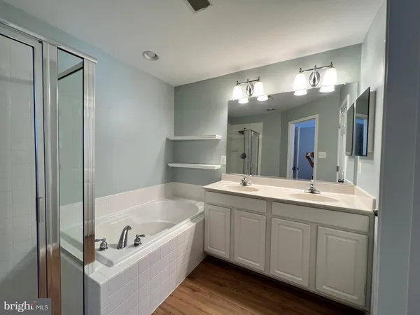 a bathroom with a tub a sink and mirror