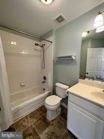 a bathroom with a granite countertop toilet sink and a mirror