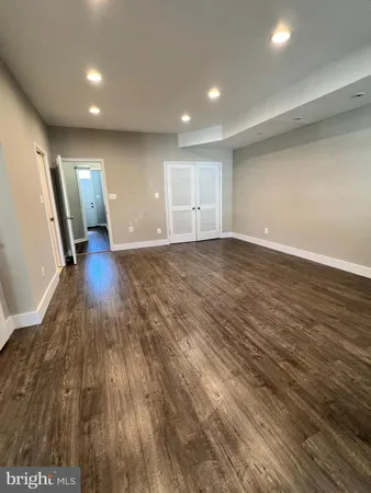 an empty room with wooden floor and front door