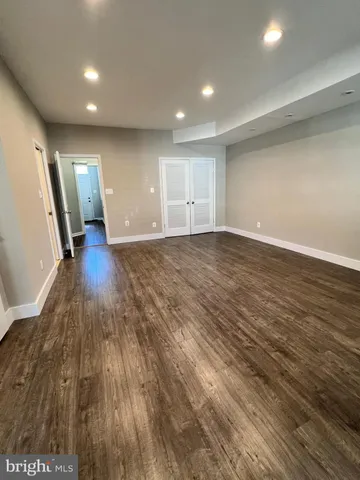 an empty room with wooden floor and front door