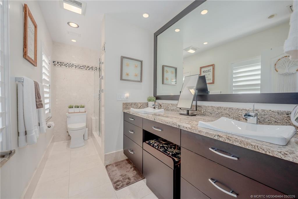 3901 Southeast St Lucie Boulevard, Unit 39 Stuart, FL 34997 - Photo 19 of 70 a spacious bathroom with a granite countertop sink a toilet a mirror and shower