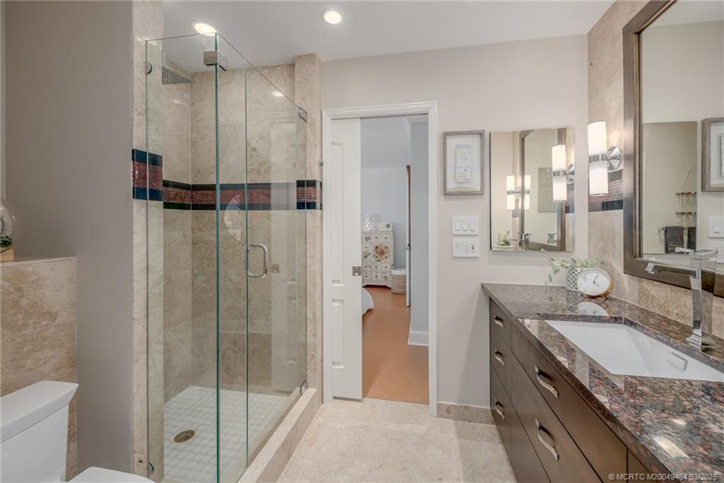 3901 Southeast St Lucie Boulevard, Unit 39 Stuart, FL 34997 - Photo 22 of 70 a bathroom with a granite countertop sink mirror and shower
