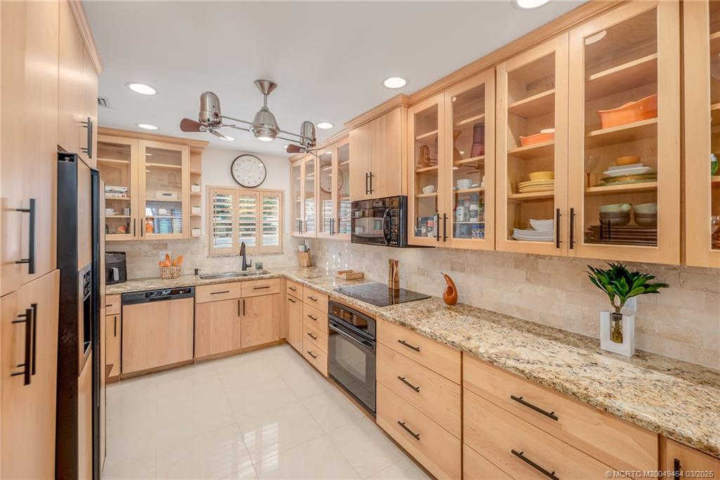 3901 Southeast St Lucie Boulevard, Unit 39 Stuart, FL 34997 - Photo 9 of 70 a large kitchen with granite countertop a lot of white cabinets and stainless steel appliances
