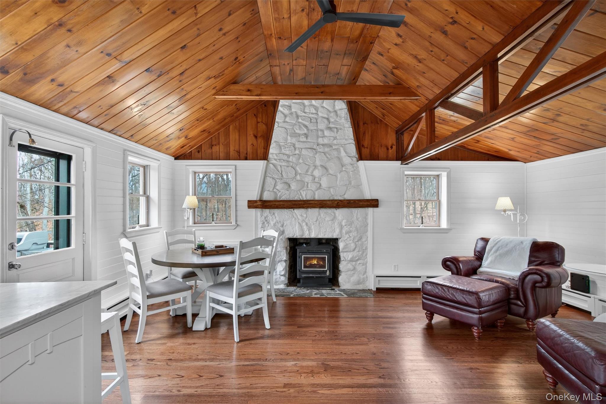 58 Oxford Springs Road Chester, NY 10918 - Photo 16 of 38 Dining room with a wooden ceiling with exposed beams, dark wood finished floors, baseboard heating, a fireplace, and wood walls