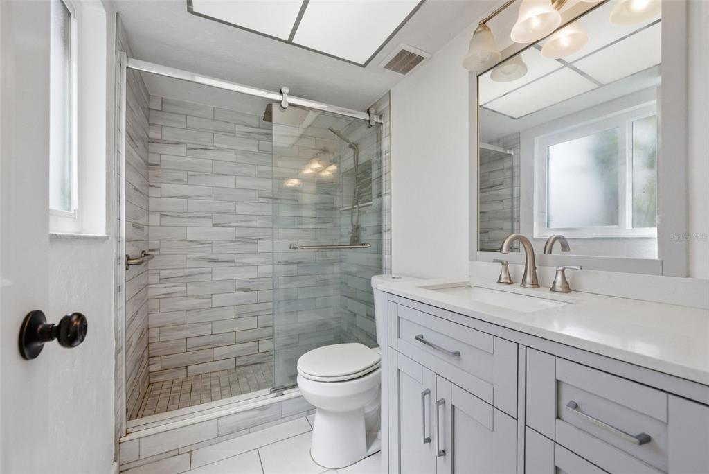 4536 Webber Street Sarasota, FL 34232 - Photo 21 of 45 a bathroom with a granite countertop sink toilet a mirror and shower