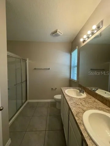 an empty room with a chandelier fan and window