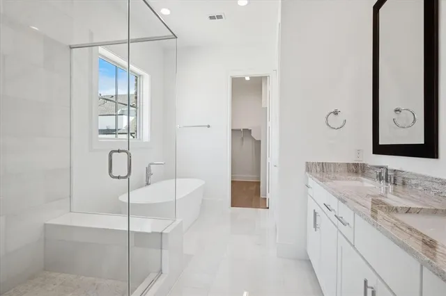 a spacious bathroom with a granite countertop sink a mirror and shower