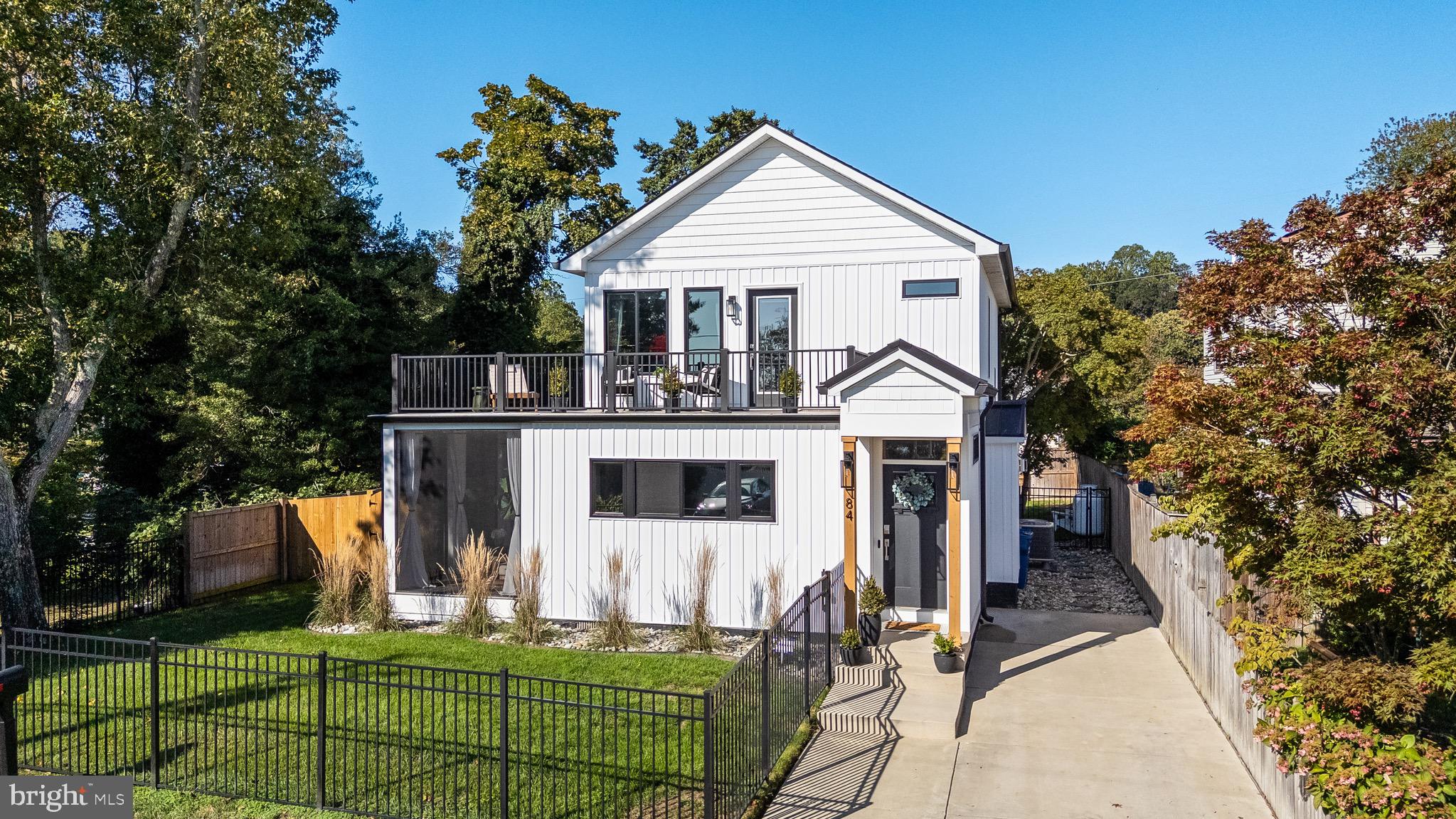 84 Chesapeake Avenue Prince Frederick, MD 20678 - Photo 1 of 42 a view of a white house with large trees and couches chairs