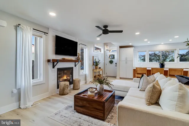 a living room with furniture a fireplace and a flat screen tv