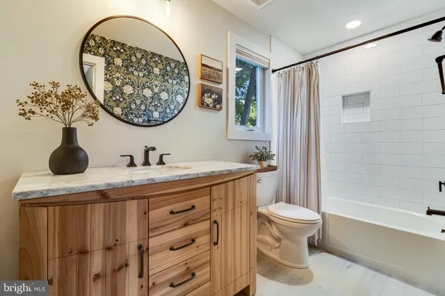 a bathroom with a granite countertop sink a toilet and a mirror