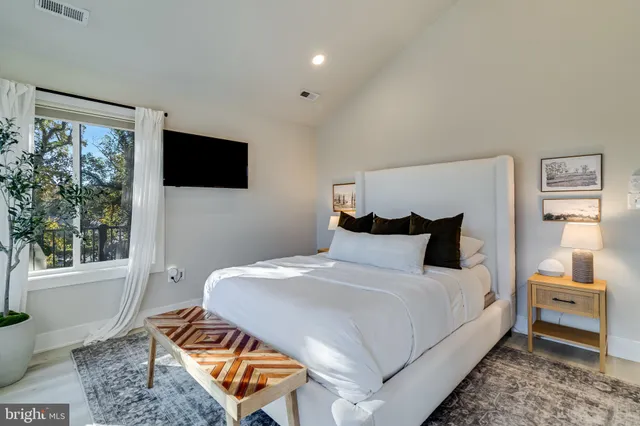 a bedroom with a bed a flat screen tv and a couch