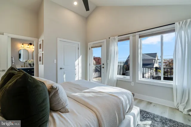 a bedroom with a bed and a large mirror next to a window