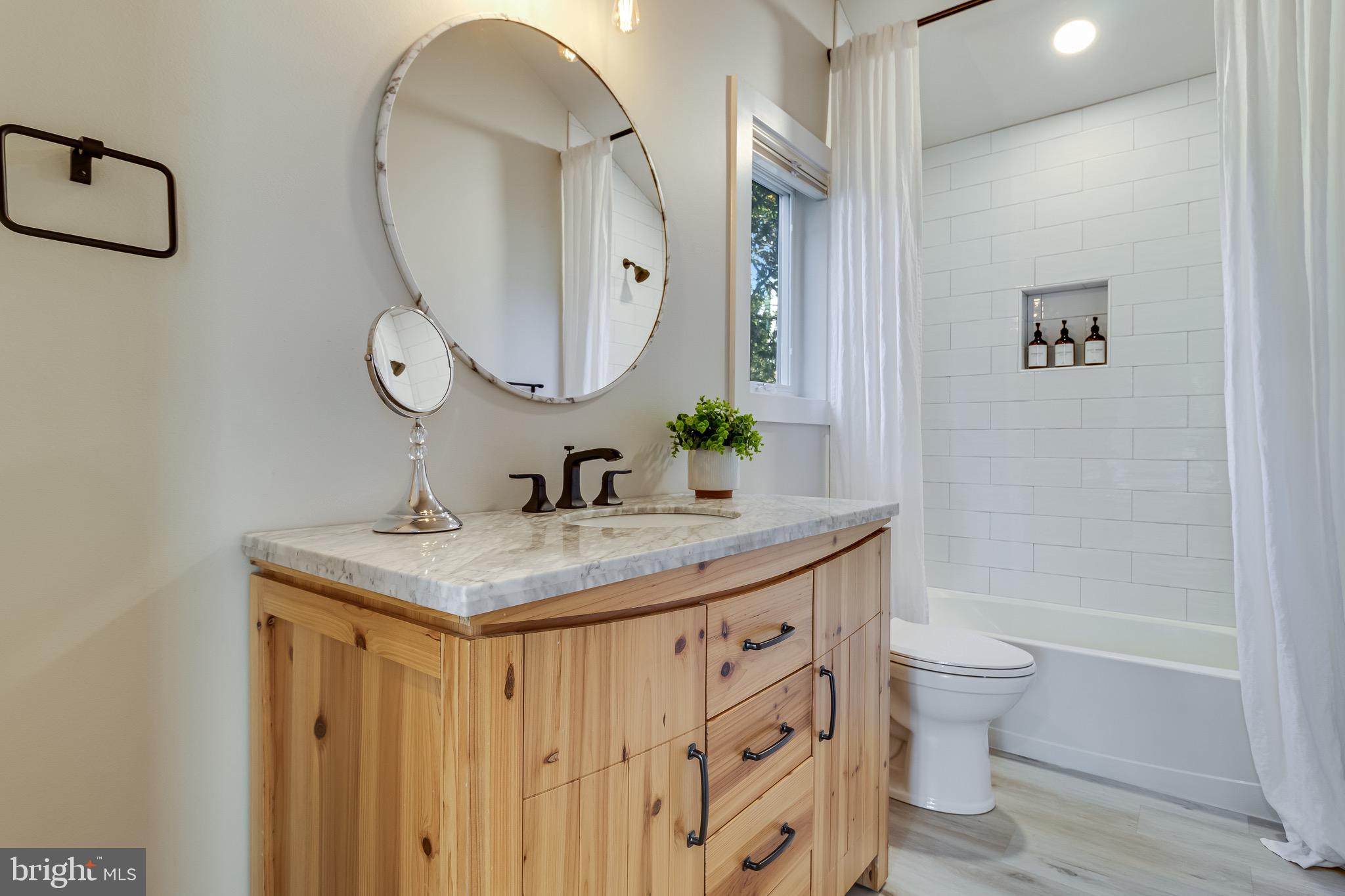 84 Chesapeake Avenue Prince Frederick, MD 20678 - Photo 32 of 42 a bathroom with a granite countertop sink a toilet and a mirror