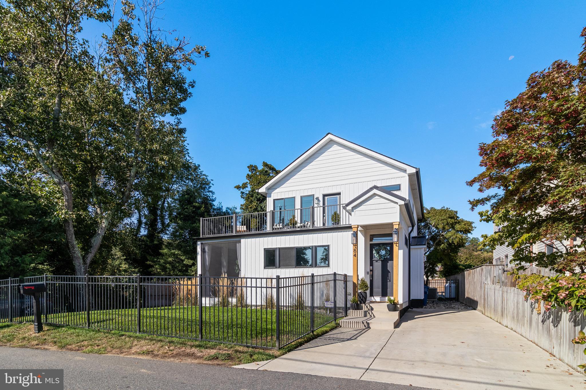 84 Chesapeake Avenue Prince Frederick, MD 20678 - Photo 34 of 42 a view of a white house next to a yard with big trees