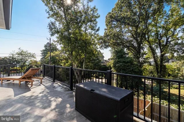 a view of roof deck with furniture and trees